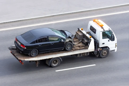 remorque derri&egrave;re une voiture dans le parking de la boutique de location