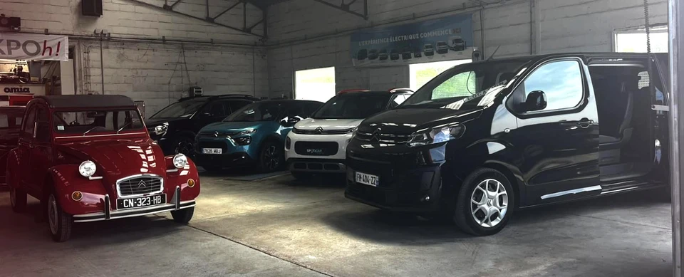 Concession automobile Peugeot avec façade bleue et logo lion, plusieurs véhicules exposés devant le showroom vitré