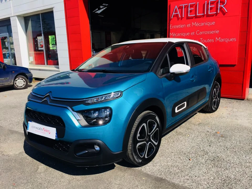 Groupe de mécaniciens de voitures jeunes et seniors portant l'uniforme avec casquette et gants dans le garage jouant et célébrant avec la danse et souriant les mains en l'air tout en tenant un plan de détourage