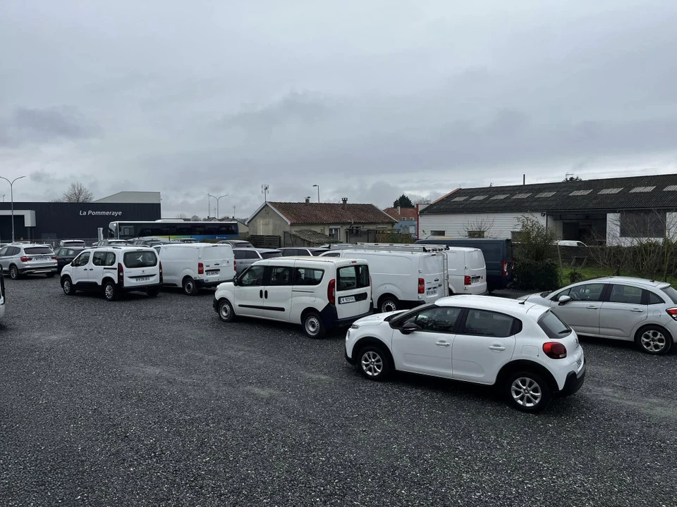 Scène intérieure avec contrat de vente automobile, billets d'euros (500€ et 100€) et clé de voiture noire sur surface blanche