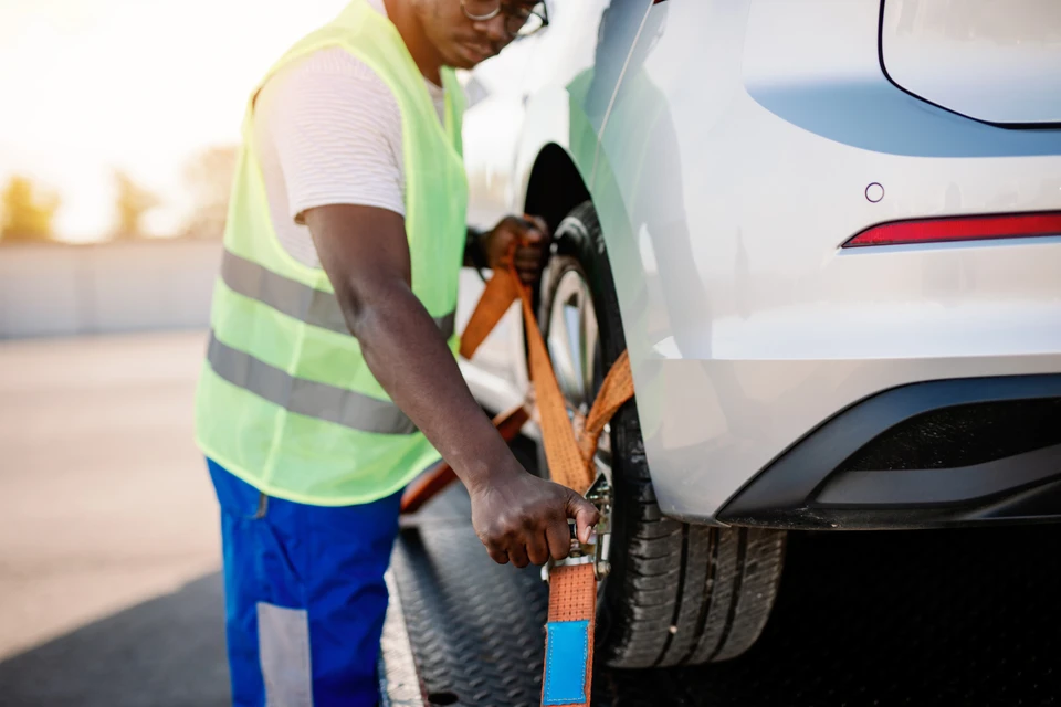 Scène extérieure montrant un opérateur en chemise rayée bleue manipulant les commandes d'un engin de chantier jaune